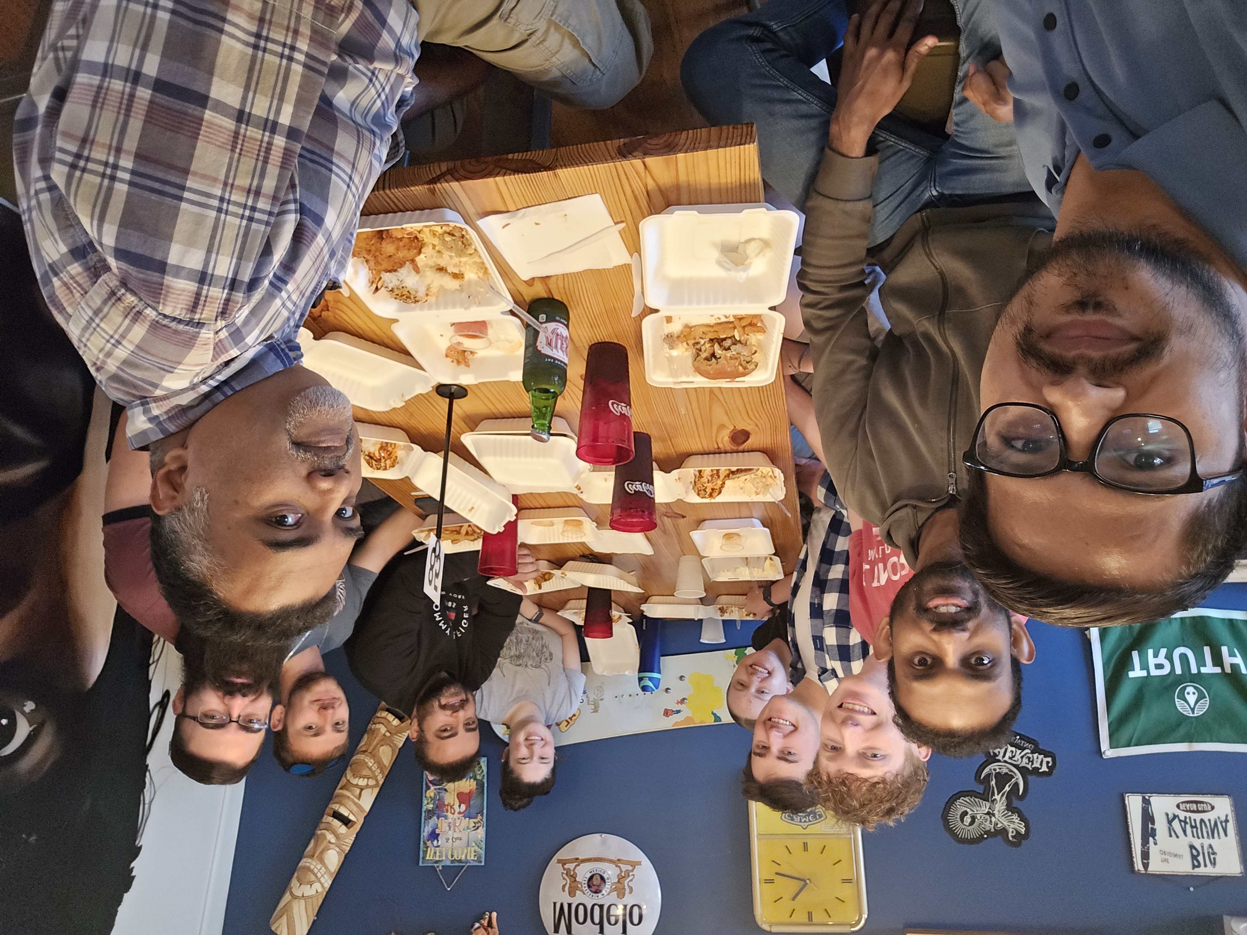 Photo of Dr. Abheetha Peiris and nine students at a restaurant seated around a table.